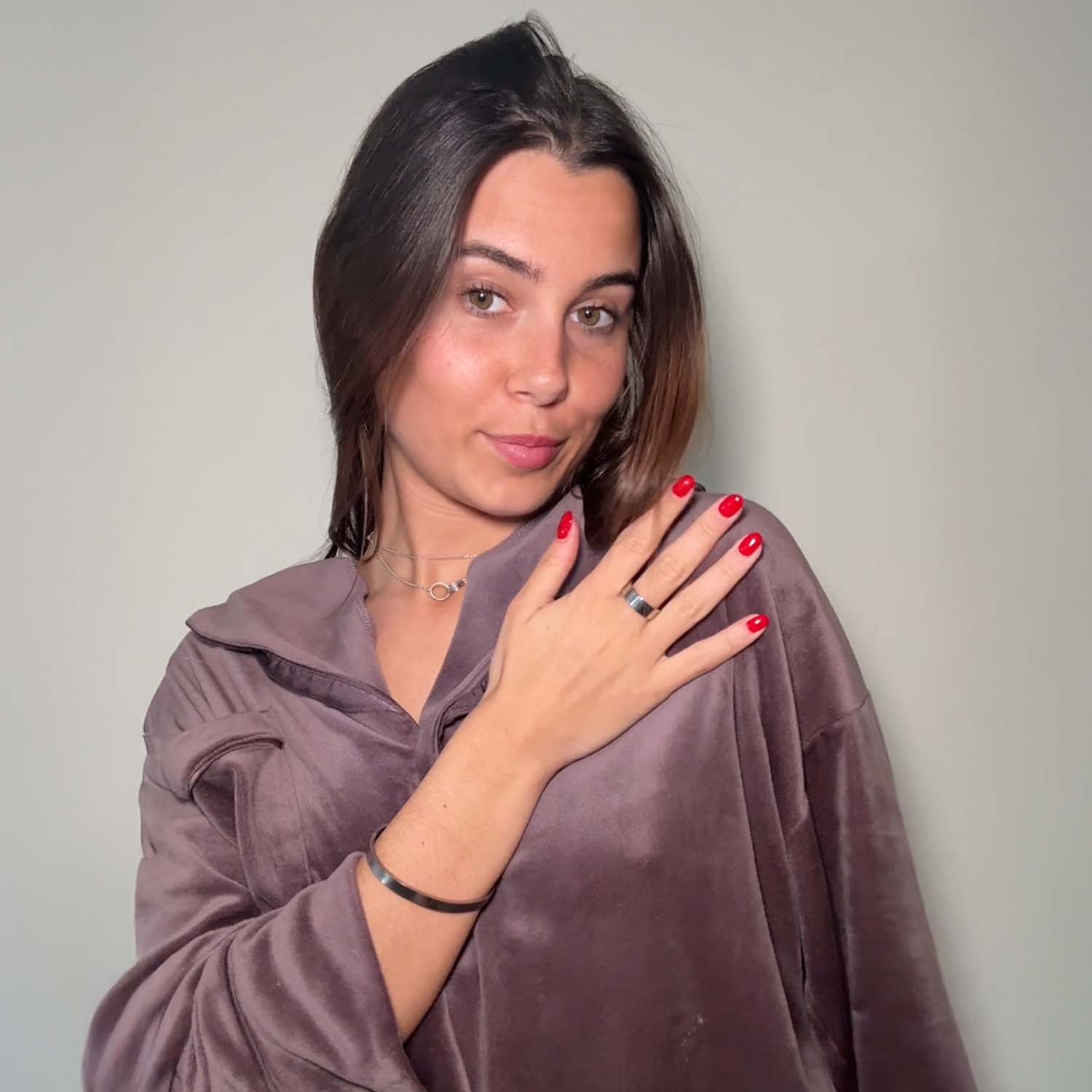 Woman wearing a purple robe against a plain background wearing calmara steel chrome bundle